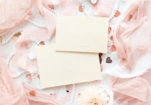 Blanco kaartjes met roze linten en hartjes voor een babyshower