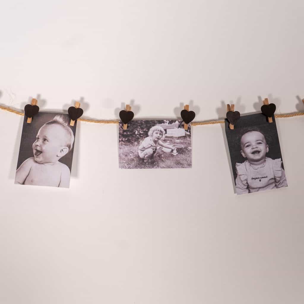 Babyfoto’s aan een lijn met hartjesknijpers voor het babyshowerspel raad de babyfoto